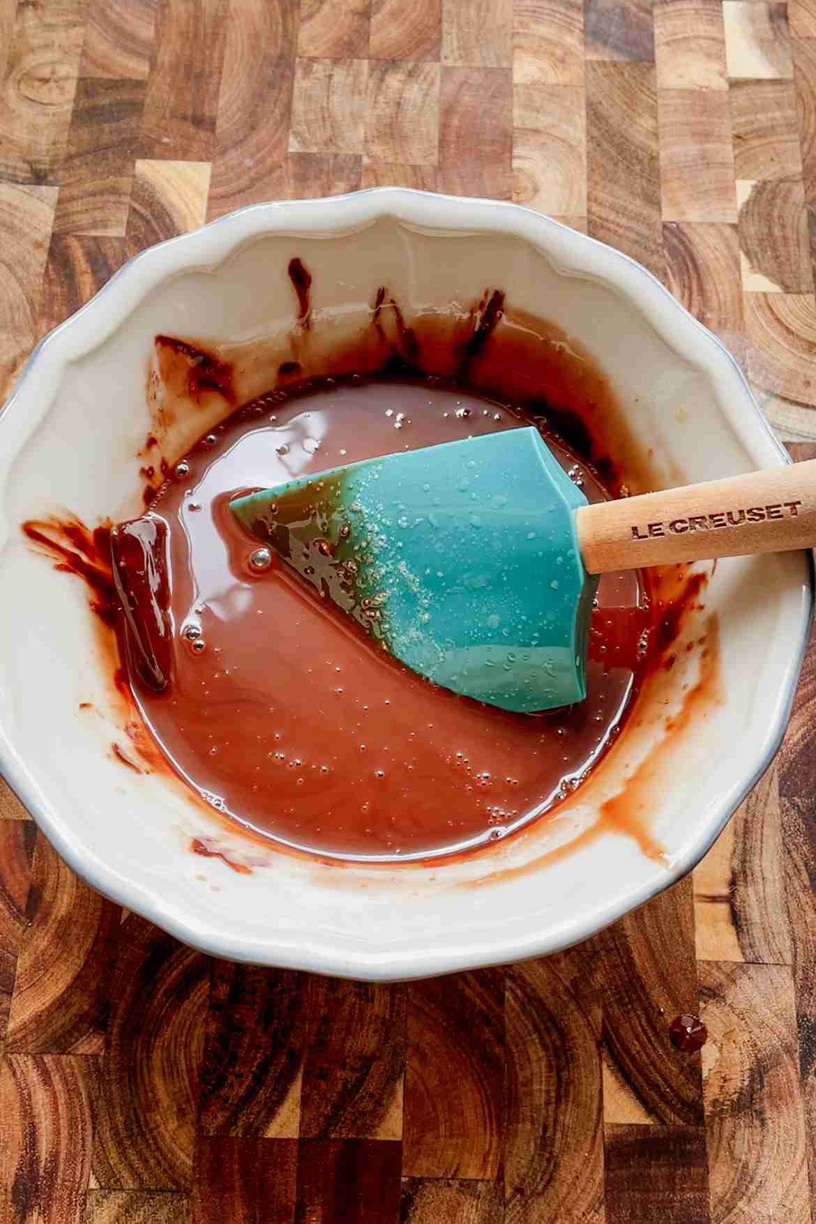 Dark chocolate melting into warm brown butter in a saucepan