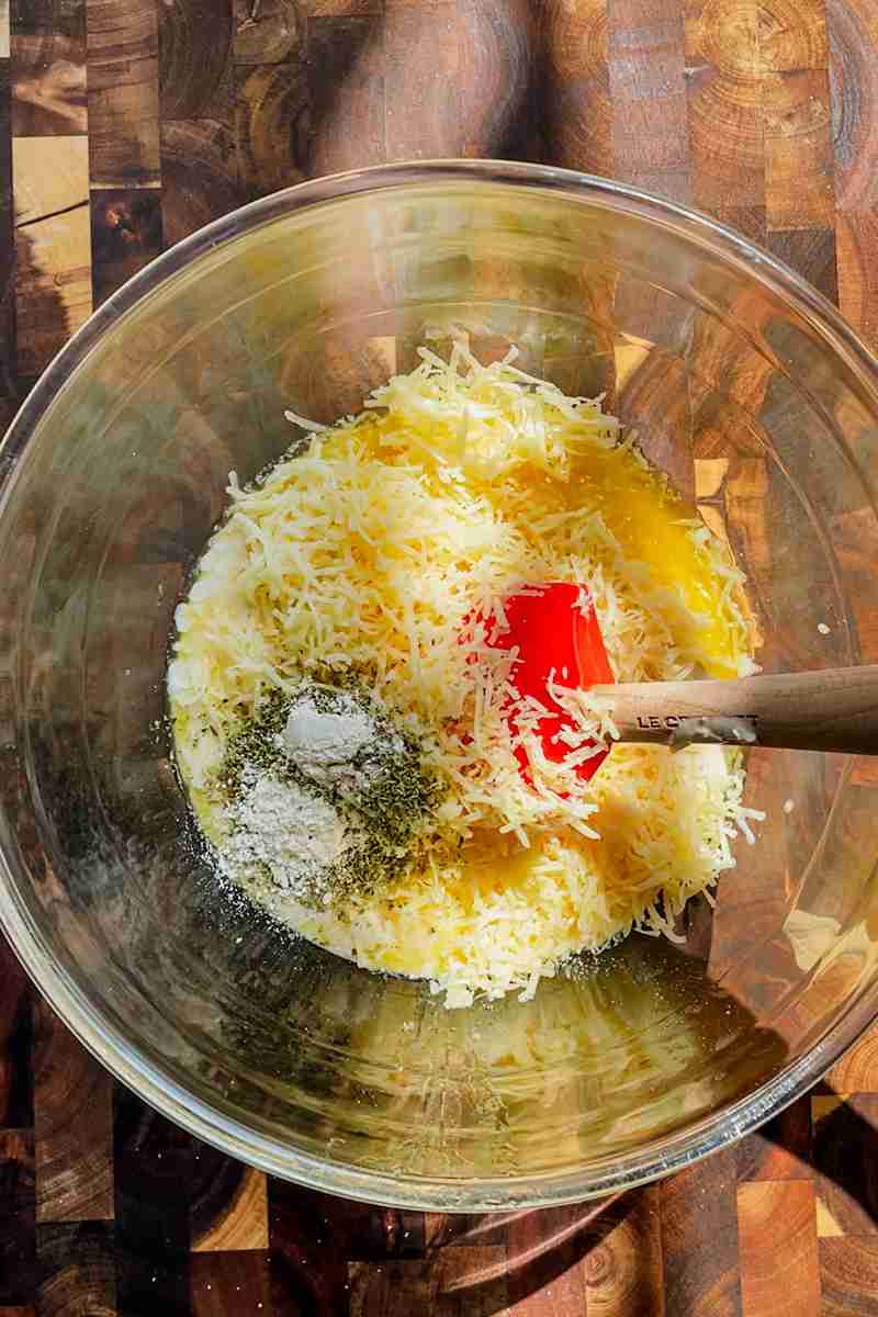 Sourdough starter, butter, cheese, and seasonings in a bowl before mixing.