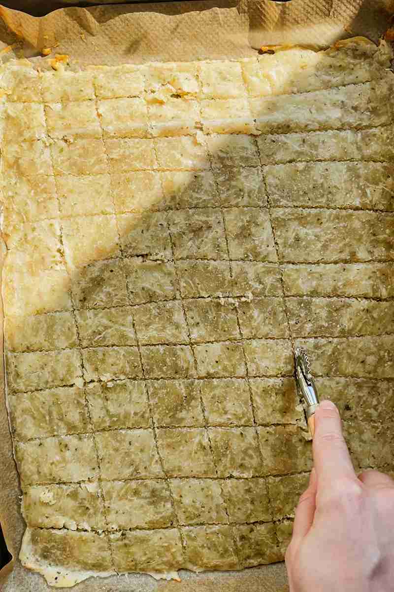 Sourdough cheese cracker dough scored into small squares.