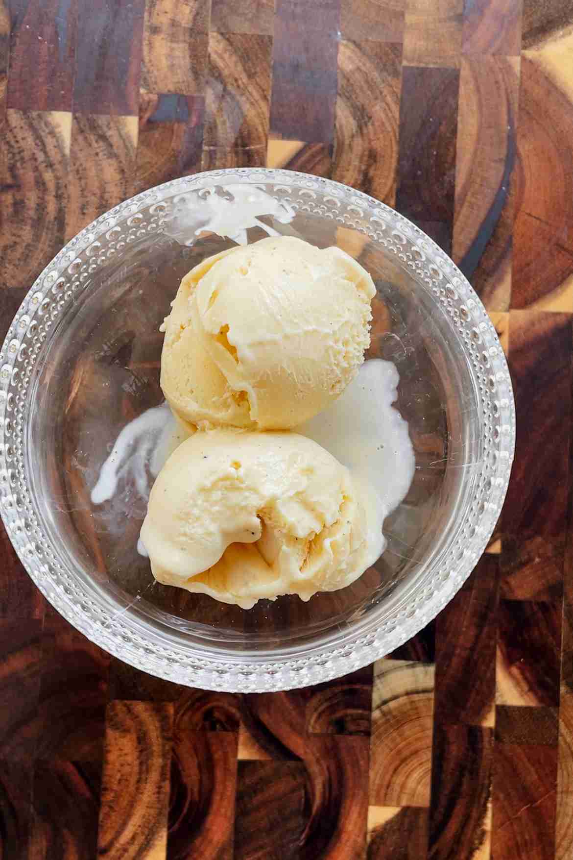 Scoops of homemade vanilla custard ice cream in a bowl showing a creamy texture