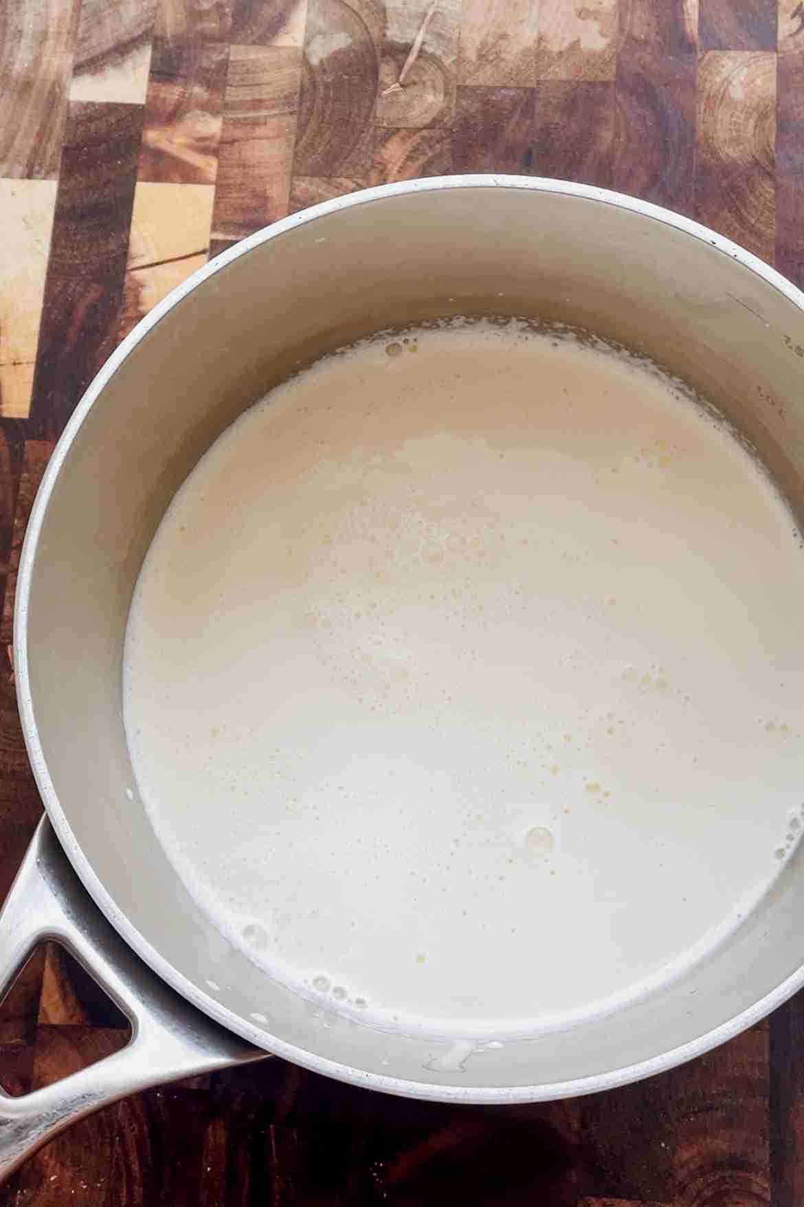 Milk and heavy cream warming in a saucepan for vanilla custard ice cream