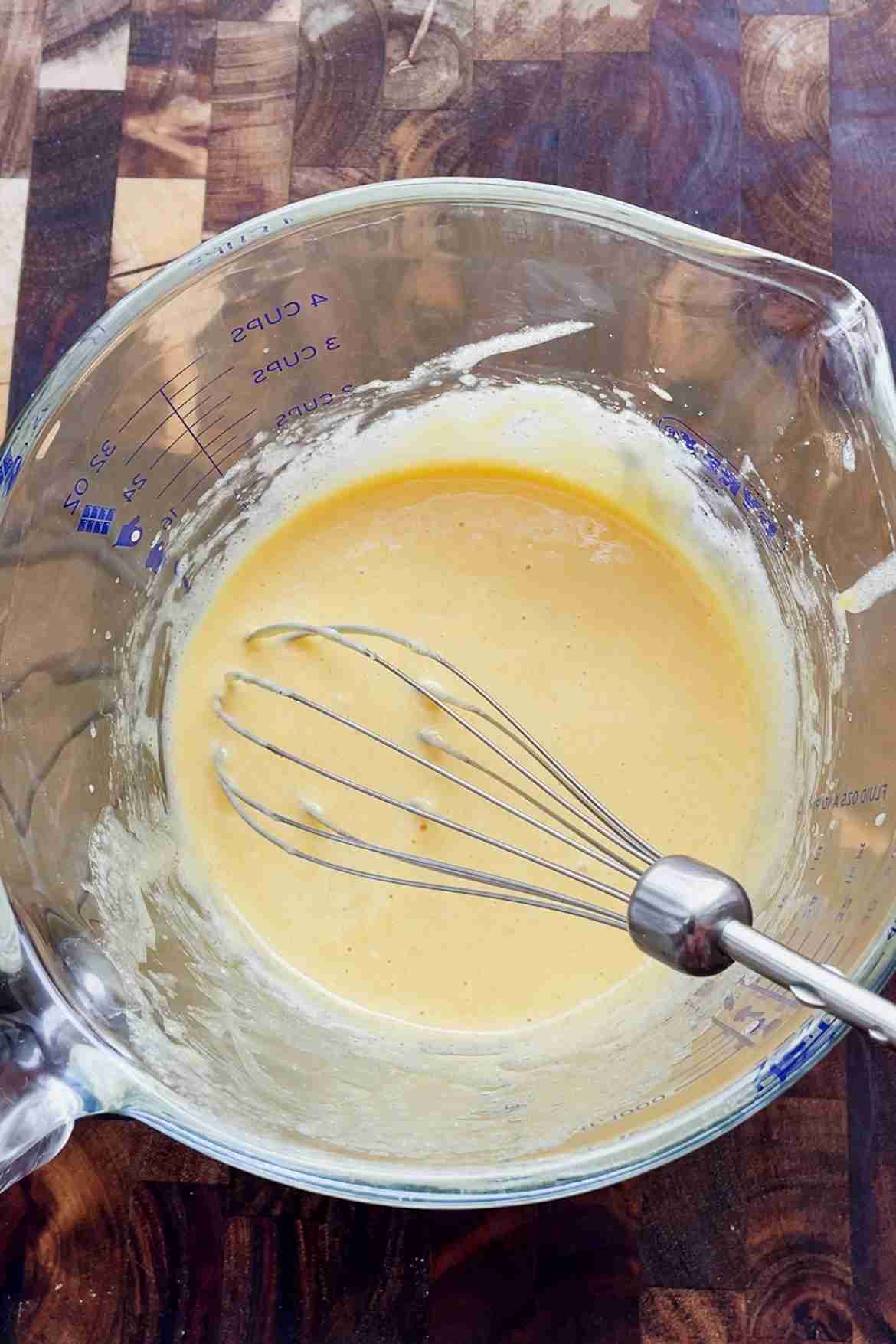 Egg yolks and sugar whisked together in a bowl for custard ice cream