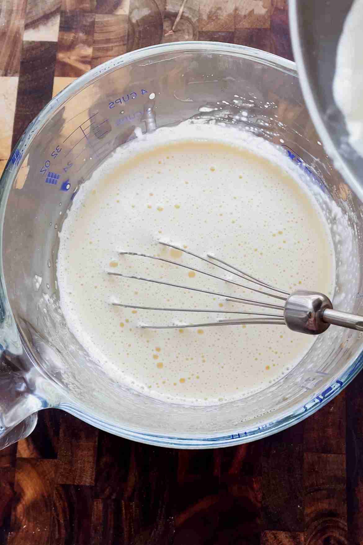 Tempering egg yolks with warm milk for vanilla custard ice cream