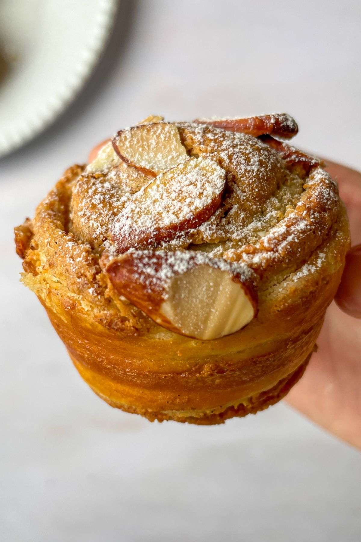 Close-up of a sourdough almond cruffin showing flaky puff pastry layers and almond frangipane inside