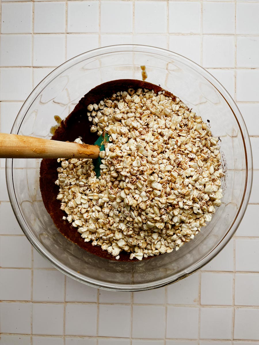 puffed buckwheat being mixed into melted chocolate for chocolate crunch bars