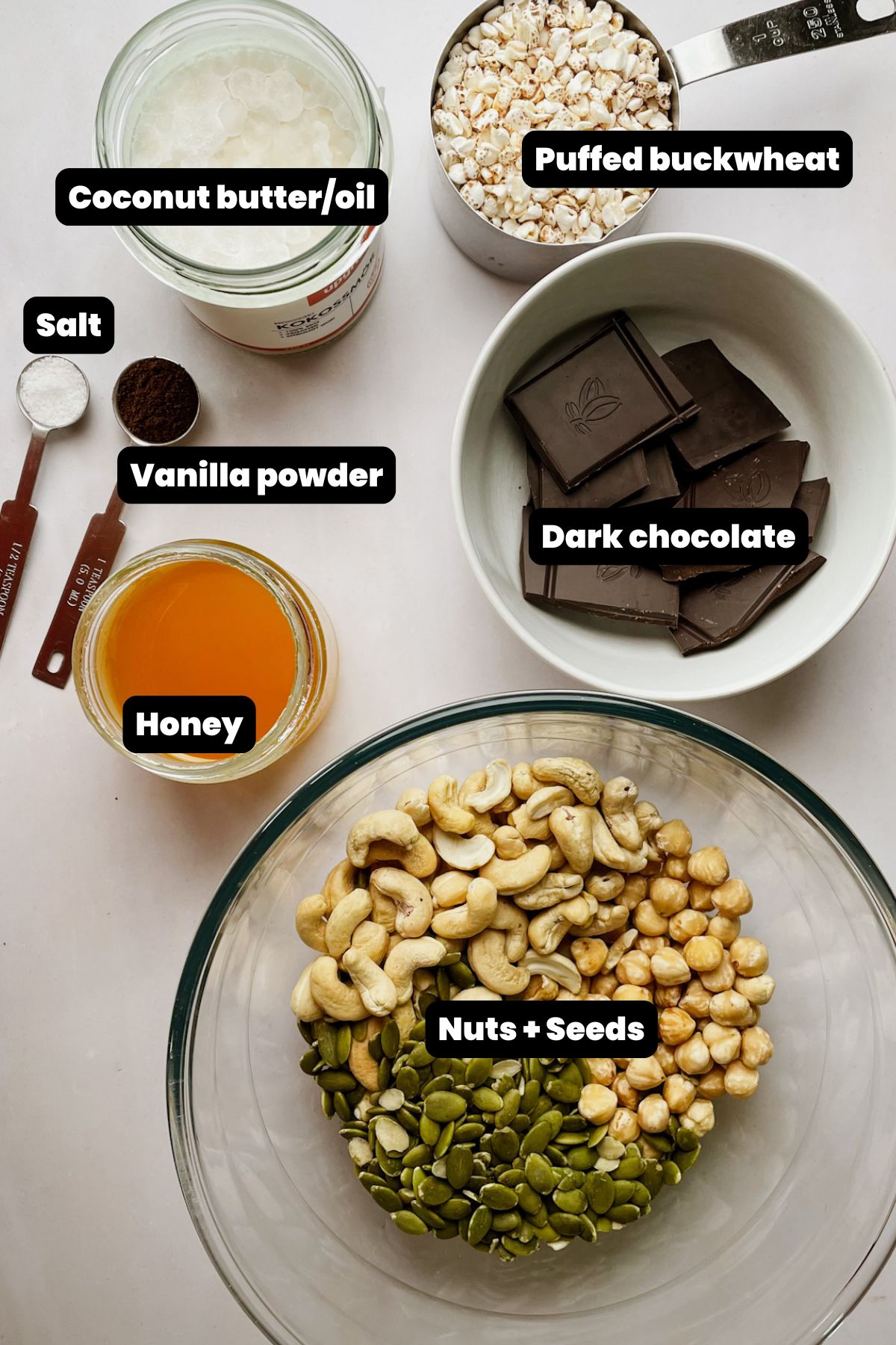 Ingredients for dark chocolate nut bars including cashews hazelnuts pumpkin seeds puffed buckwheat honey and dark chocolate