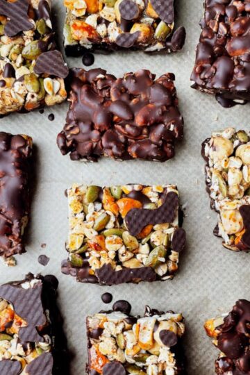 Dark chocolate nut bars with sea salt dipped in chocolate on parchment paper