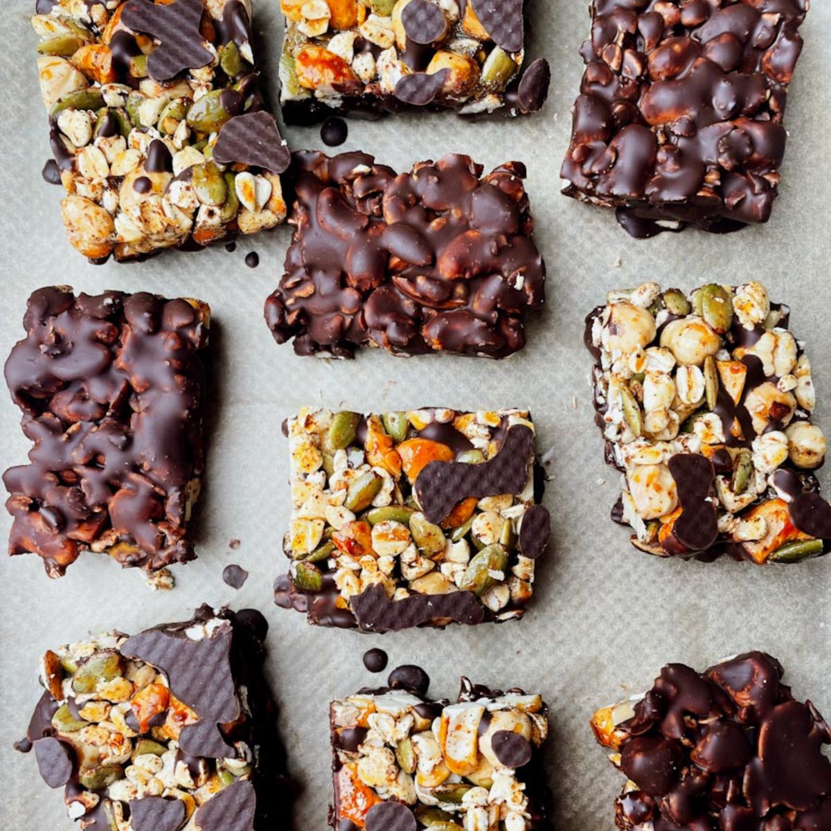 Dark chocolate nut bars with sea salt dipped in chocolate on parchment paper