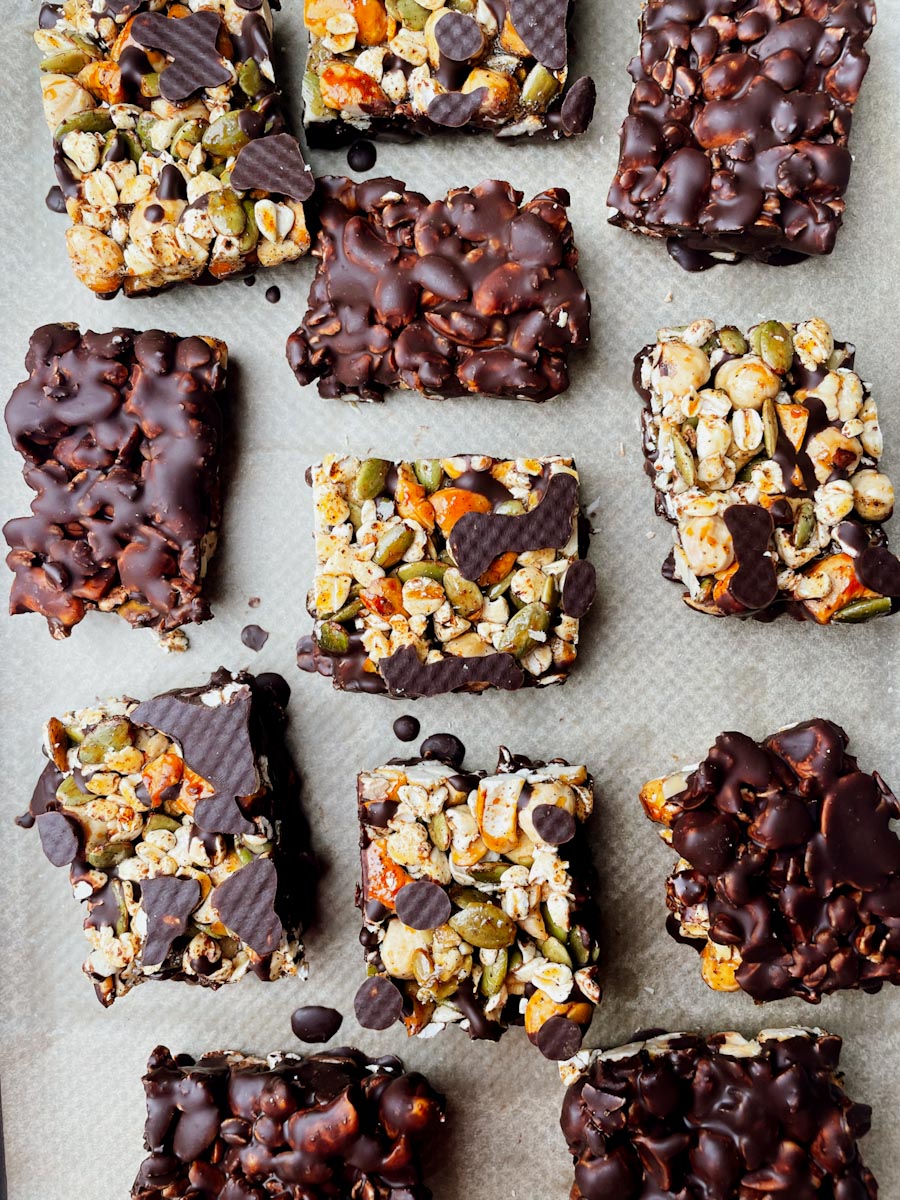 Dark chocolate nut bars with sea salt dipped in chocolate on parchment paper