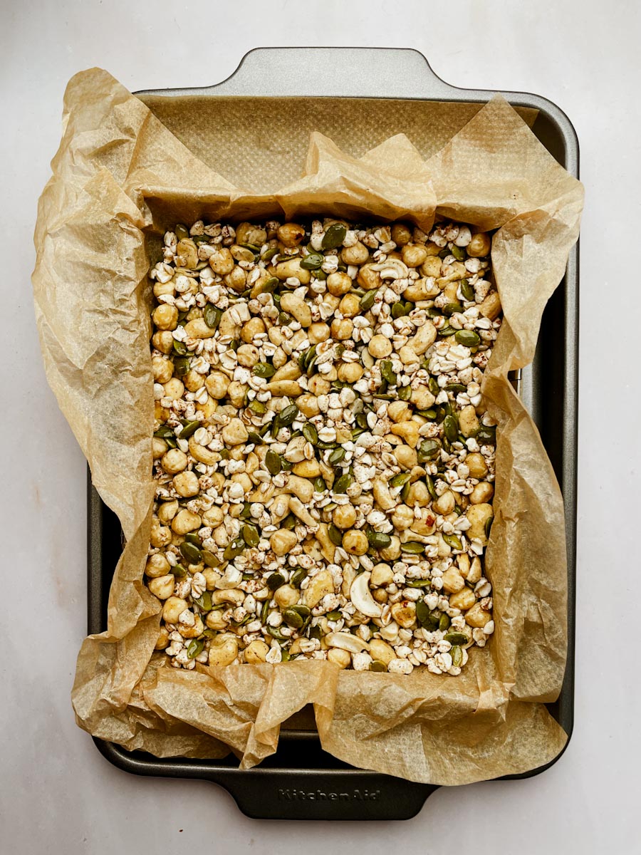 Pressing nut bar mixture into lined baking pan before baking