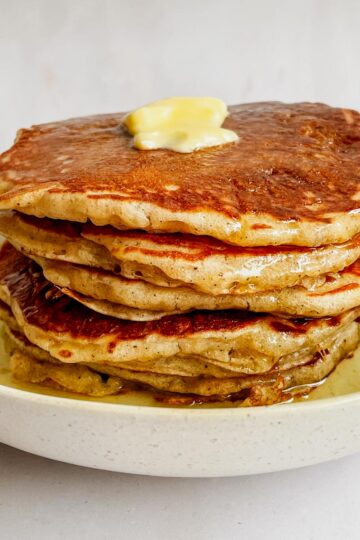 fluffy overnight sourdough pancakes stacked with butter and syrup