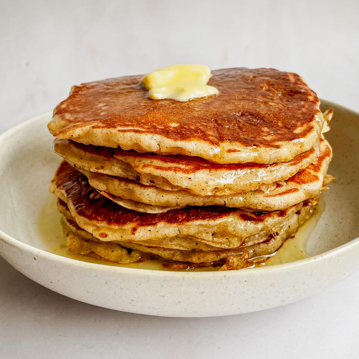 fluffy overnight sourdough pancakes stacked with butter and syrup