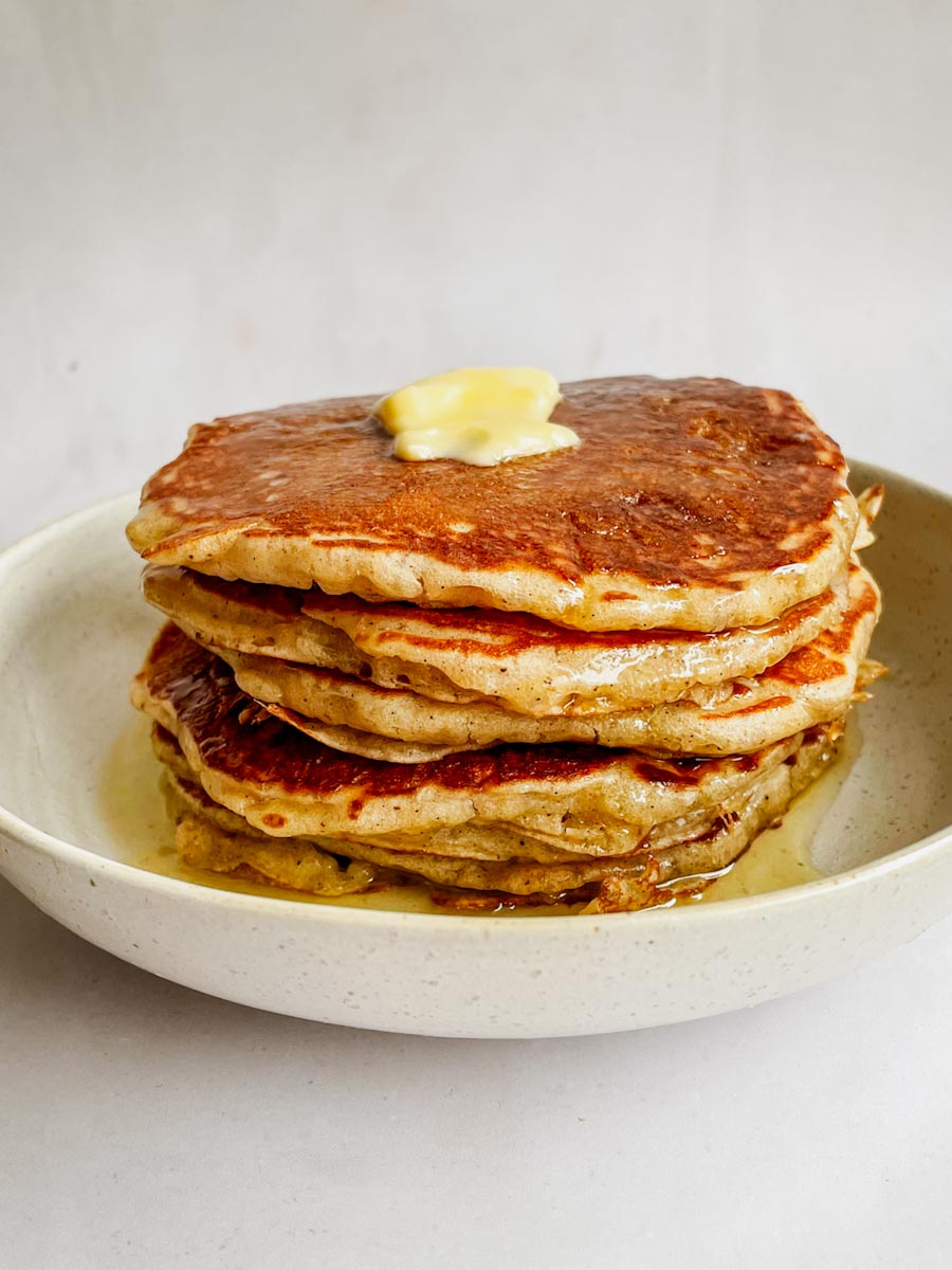 fluffy overnight sourdough pancakes stacked with butter and syrup