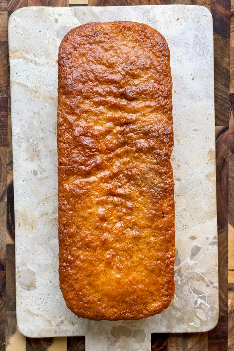 Freshly baked sourdough lemon loaf with golden crust just out of the oven