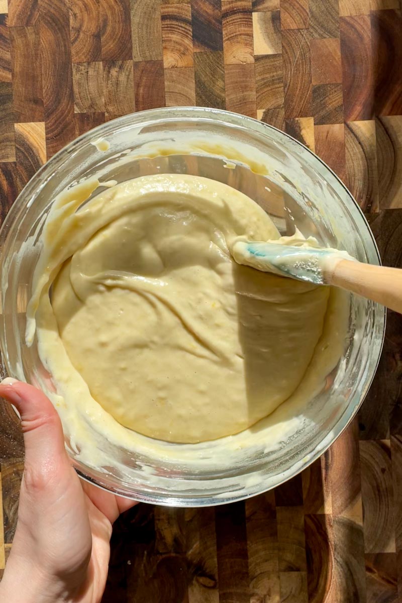 Finished sourdough lemon loaf batter in a bowl with all wet and dry ingredients combined