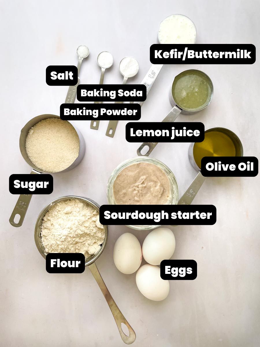 Ingredients for sourdough lemon loaf including eggs, lemon, kefir, flour, olive oil and sourdough starter