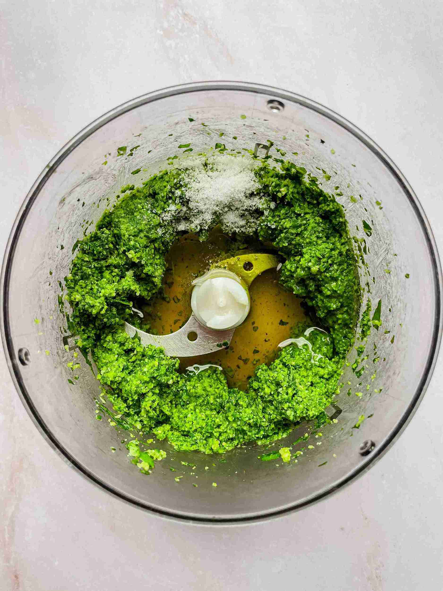 olive oil being added to pesto sauce without pine nuts while blending