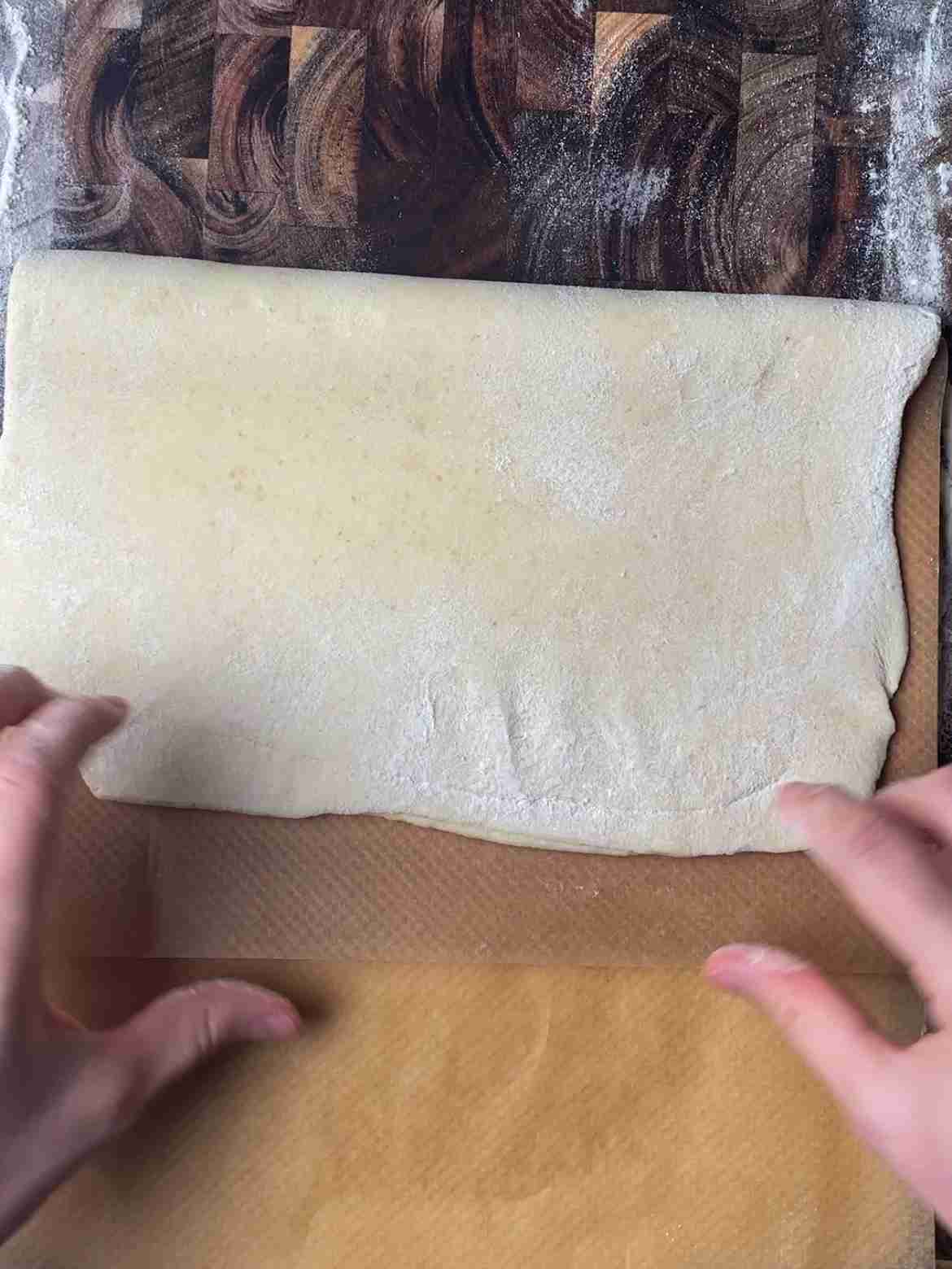 Final fold of sourdough puff pastry dough with parchment paper separating layers