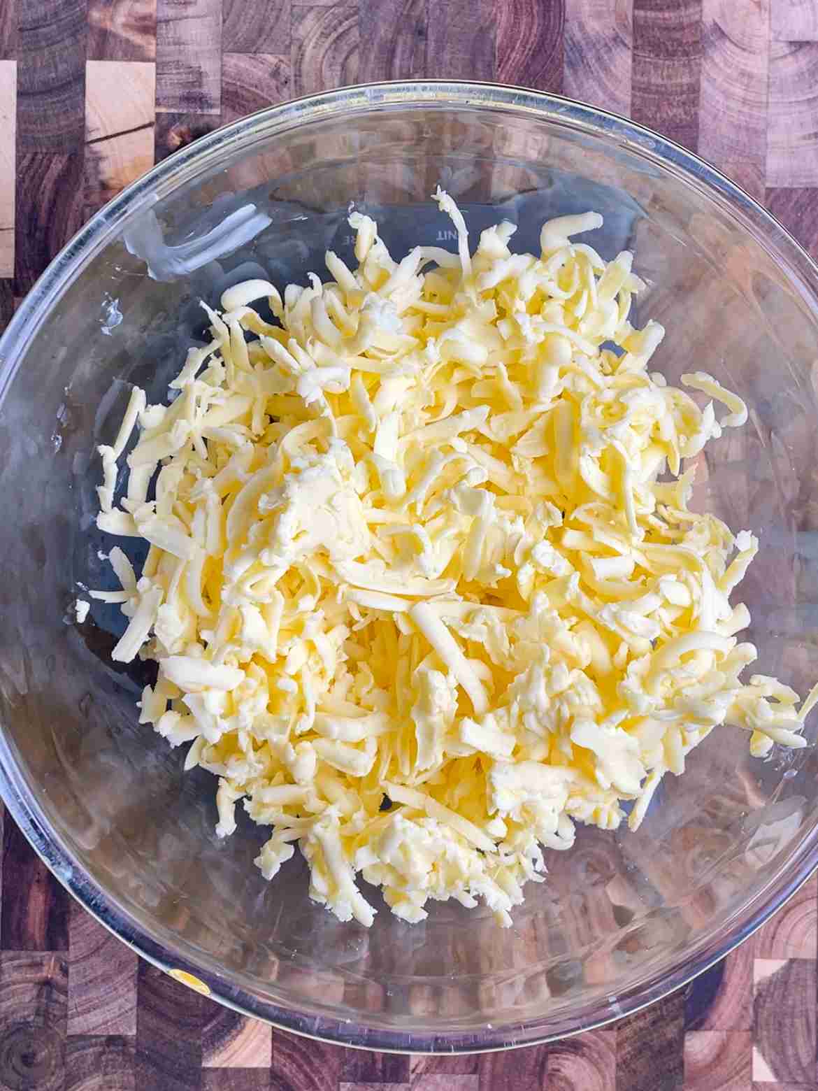 Cold butter being grated with a box grater for sourdough rough puff pastry