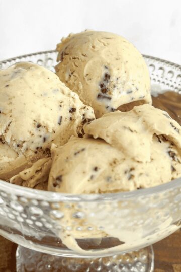 Close-up of hazelnut ice cream scoops studded with dark chocolate pieces, highlighting the rich, creamy texture.