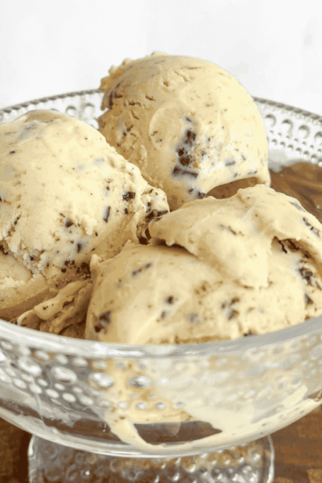 Close-up of hazelnut ice cream scoops studded with dark chocolate pieces, highlighting the rich, creamy texture.