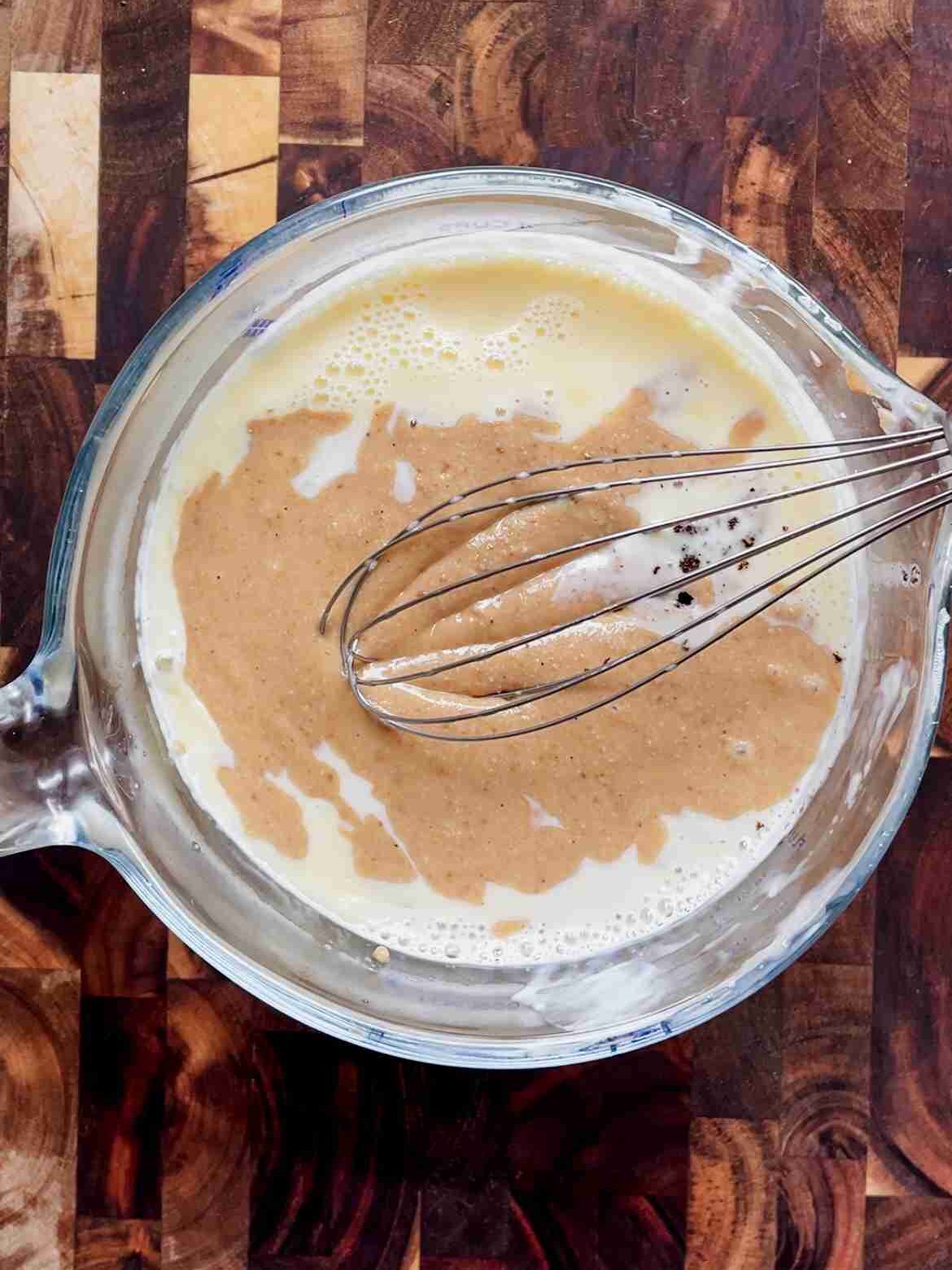Hazelnut butter and vanilla being whisked into the warm custard base.