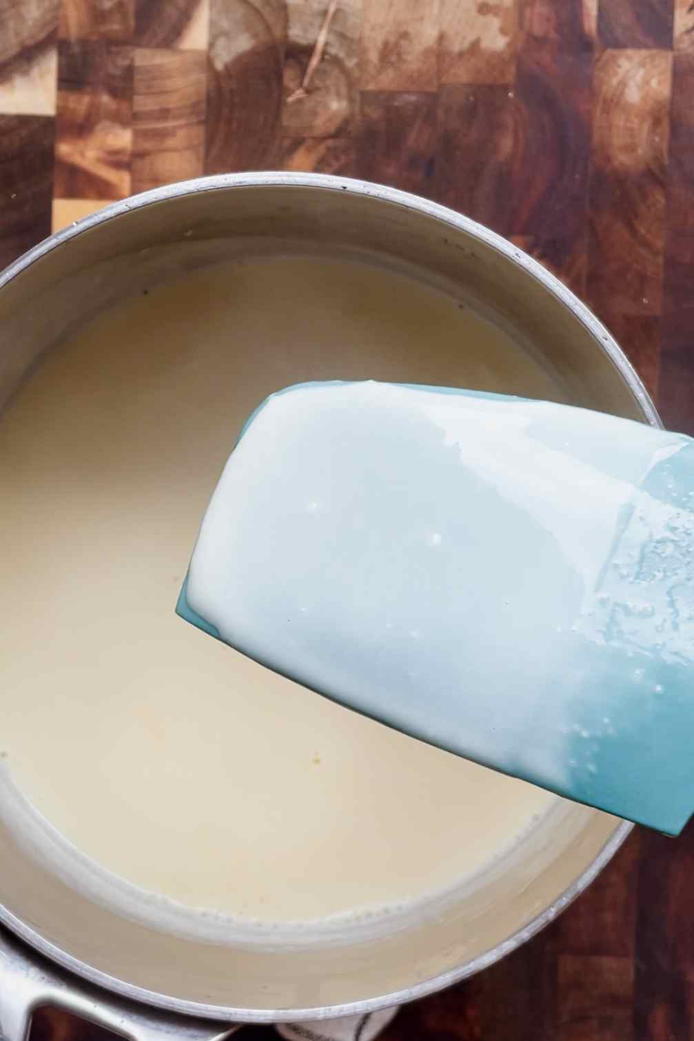 ice cream custard thickened and coating the back of a spoon, ready to remove from heat.