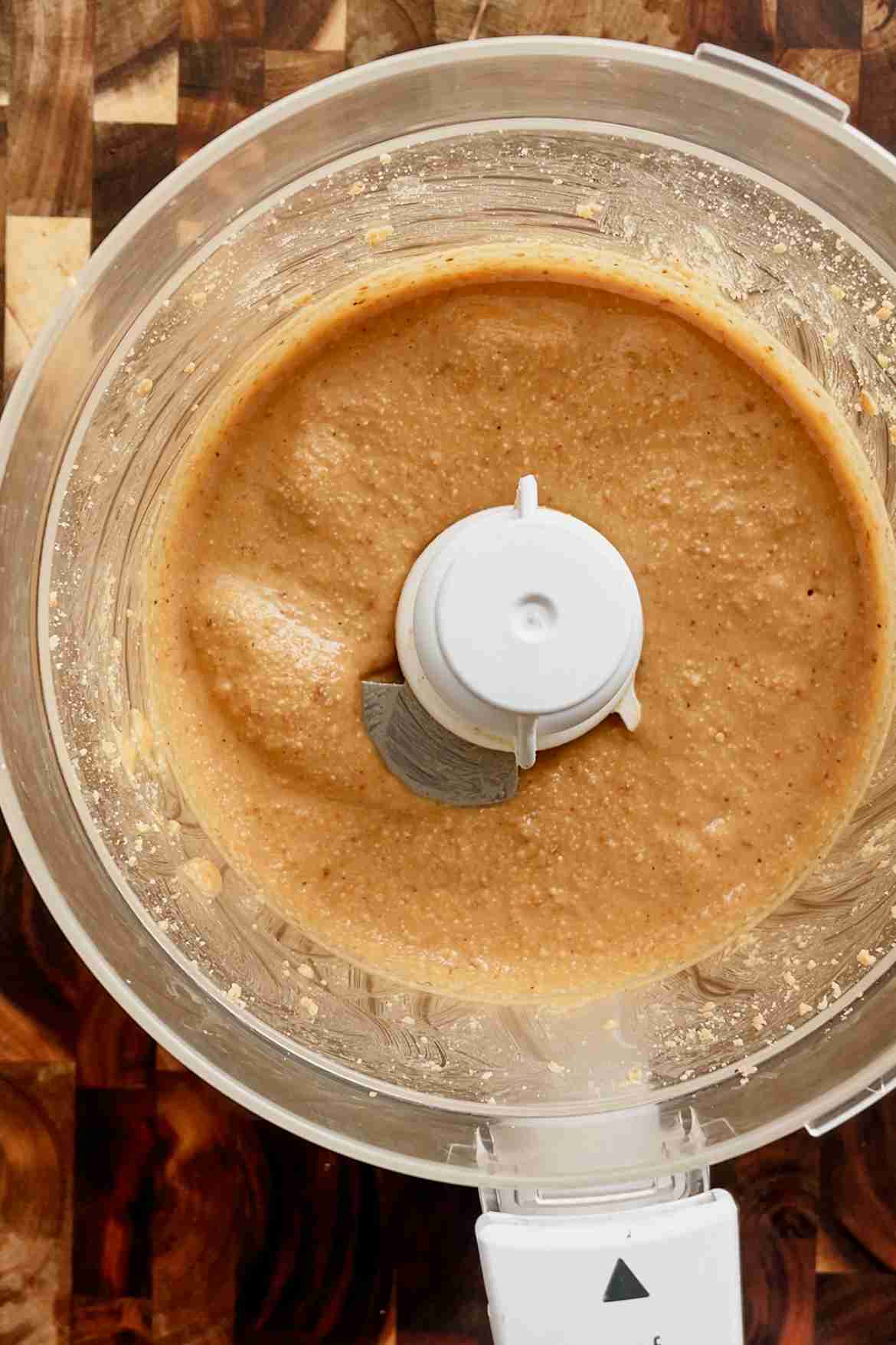Smooth, glossy homemade hazelnut butter in a food processor bowl.