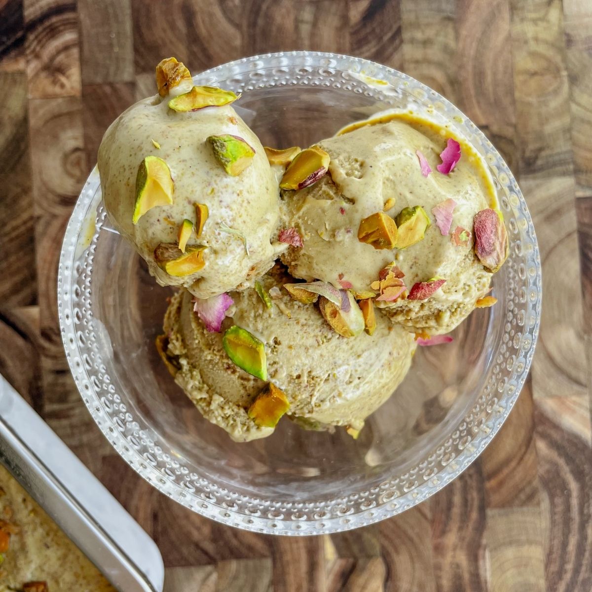Bowl of creamy homemade pistachio ice cream topped with chopped pistachios.