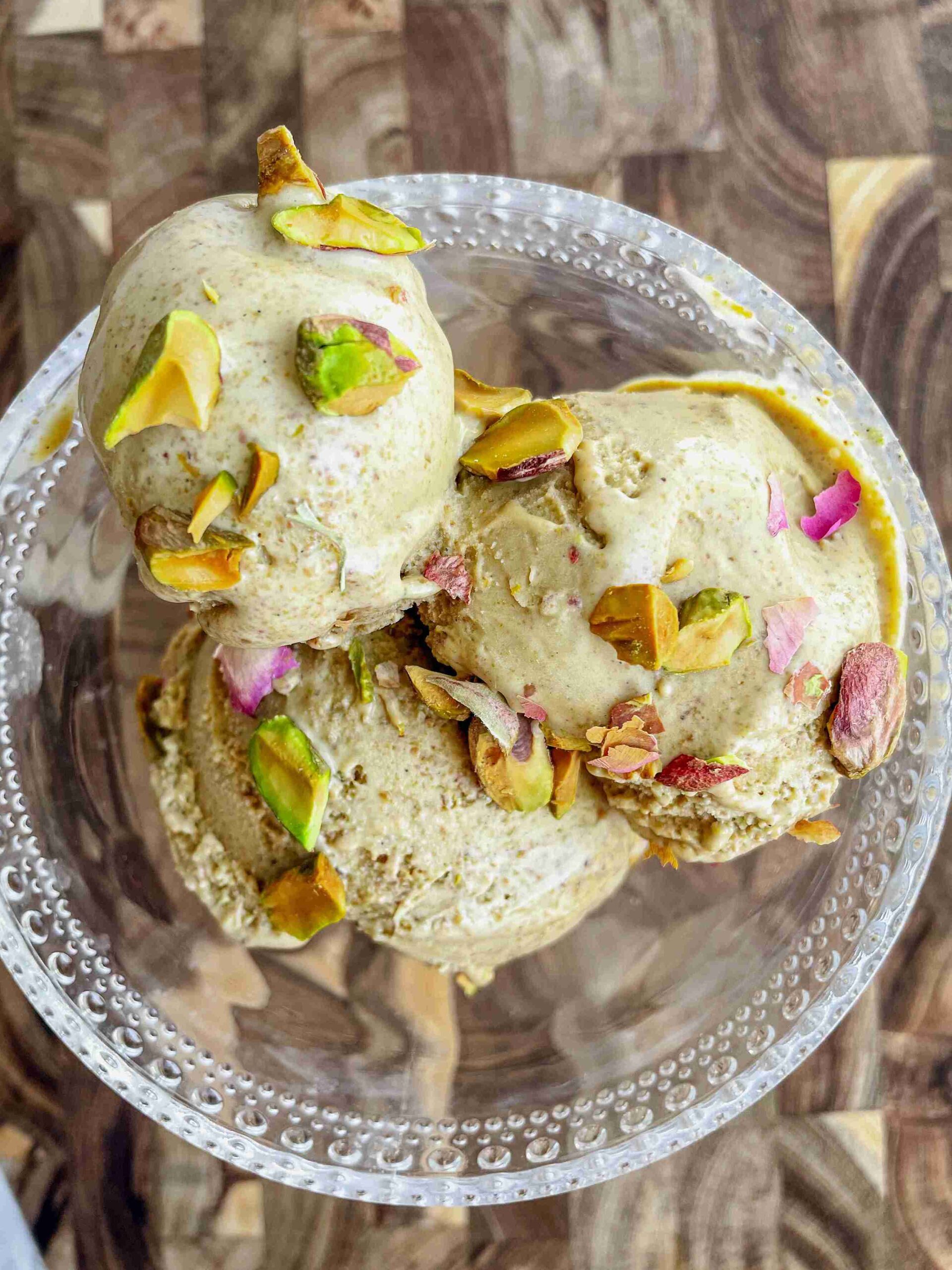 Bowl of creamy homemade pistachio ice cream topped with chopped pistachios.