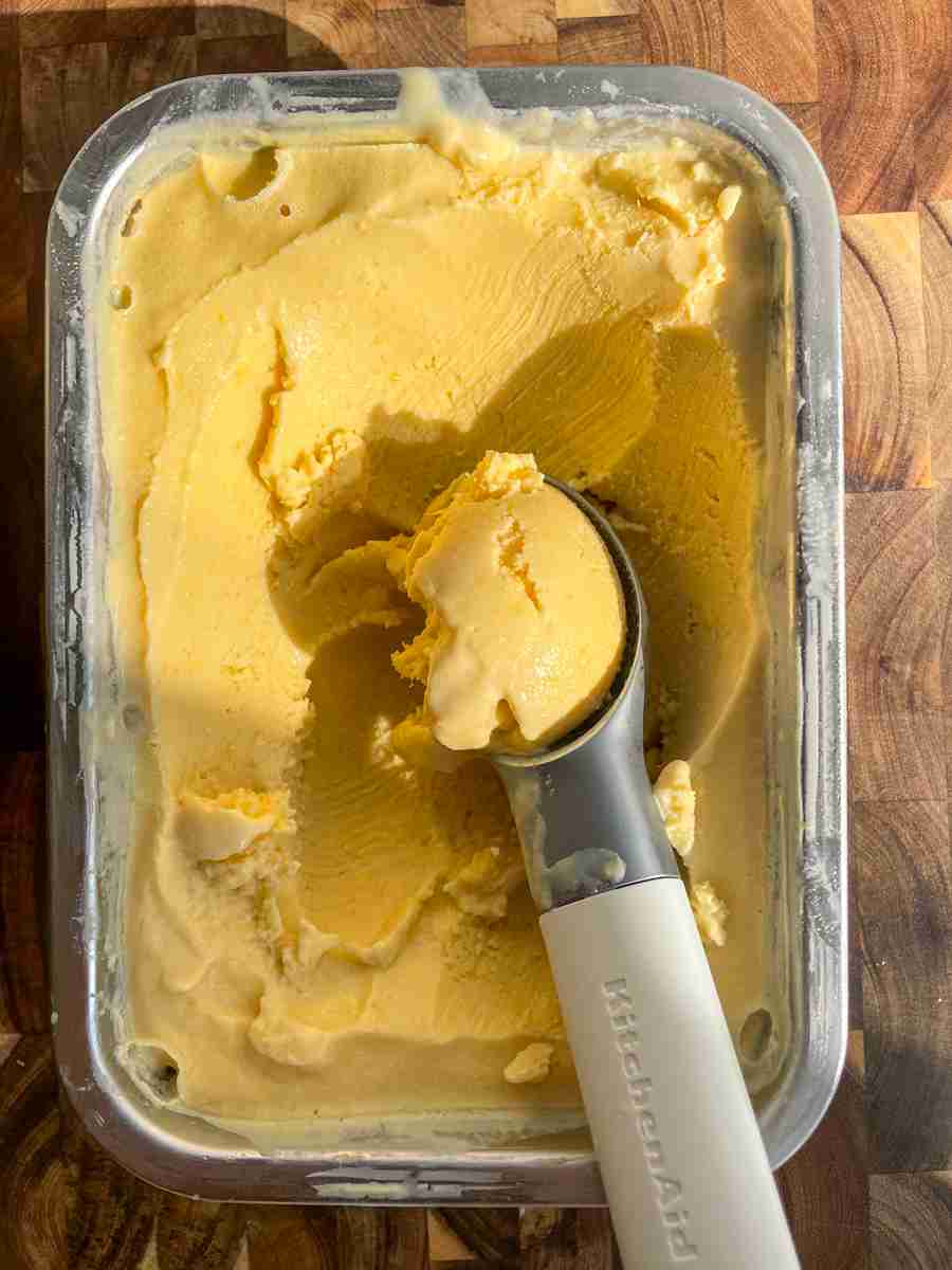 Coconut peach ice cream in a freezer-safe container after churning.